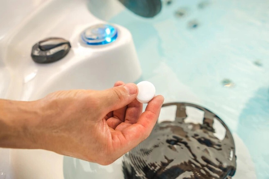 Chlorine tablets in a hot tub Adding chlorine tablet to hot tub water for proper sanitation